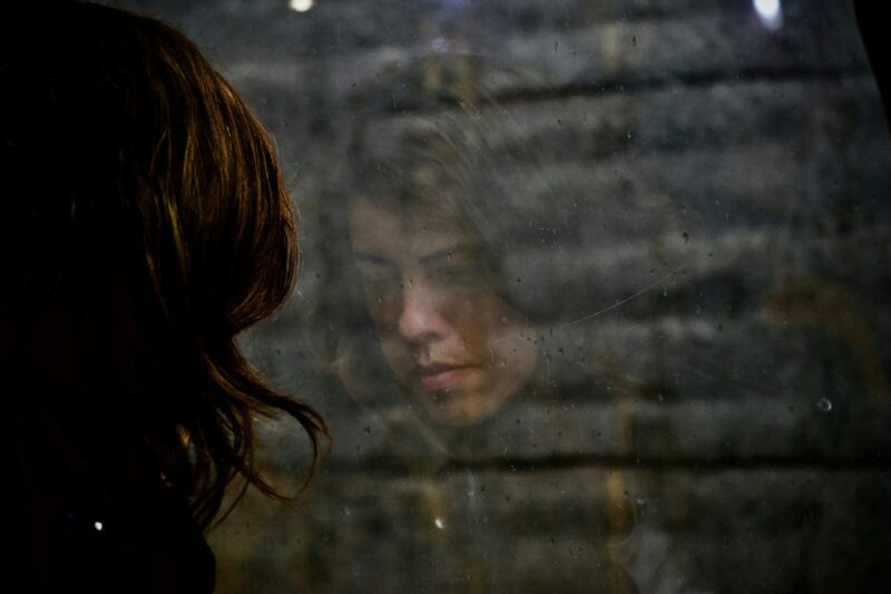 an image with a woman / mother staring out the window reflecting on mental health and motherhood