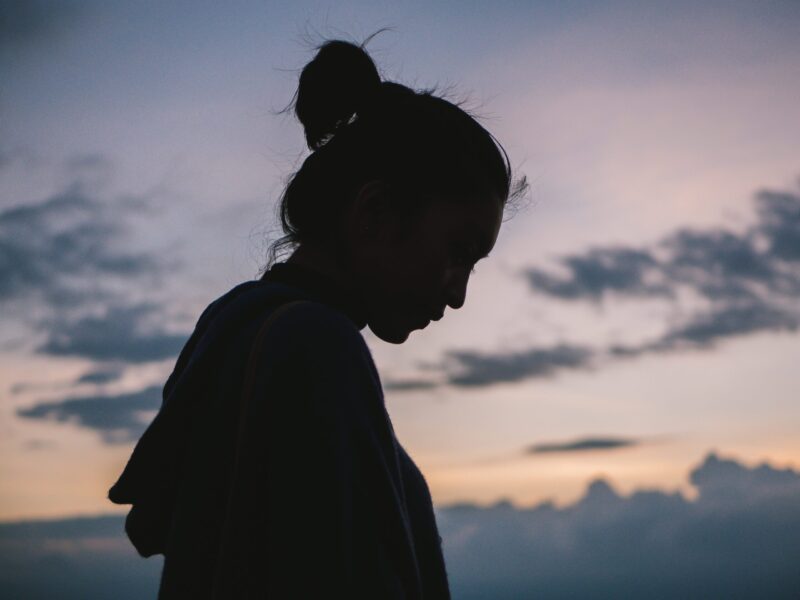 silhouette of a woman outside with sunset behind her