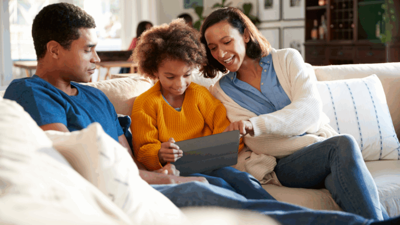 Father and mother with child looking at laptop
