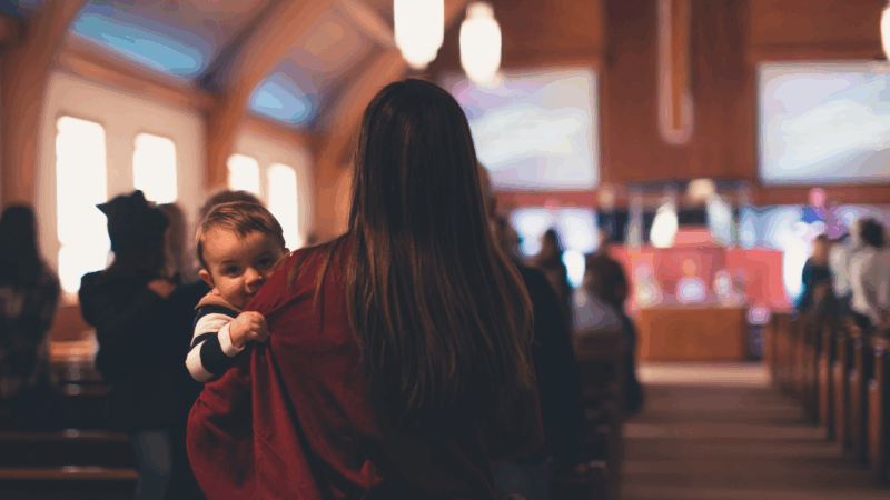 single mom holding baby during church service