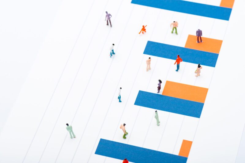 High angle view of people figures on surface with blue and orange diagram isolated on white