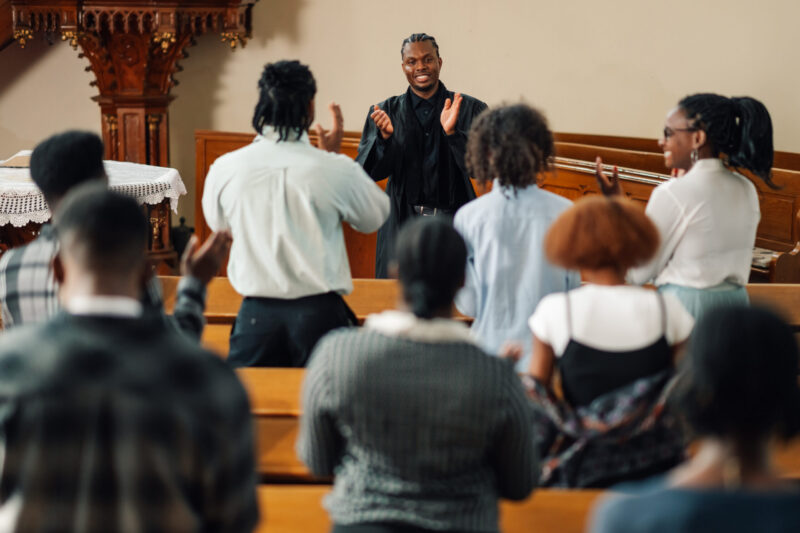 Diverse congregation gathers in a vibrant church as a passionate pastor delivers an inspiring sermon, drawing them closer in prayer and praise