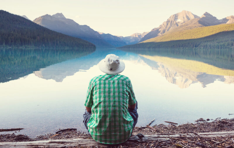 A man is resting at ease by the calm lake.
