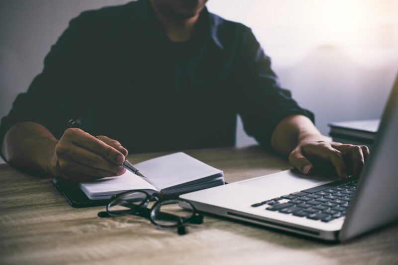 Man working at desk with laptop at night